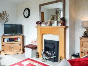 a living room with a fireplace and a mirror at Bryn Rodyn in Llanfair-Dyffryn-Clwyd
