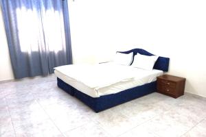 سرير أو أسرّة في غرفة في Super OYO 147 Babylon Furnished Apartment