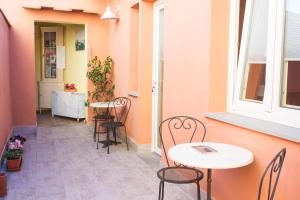 a patio with two tables and chairs and a window at La Papaya in Marina di Pisa