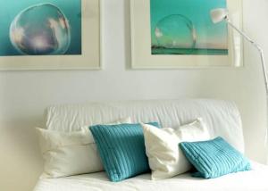 eine weiße Couch mit blauen und weißen Kissen darauf in der Unterkunft Molino Azul 3A, Wohnung mit Meerblick in Valle Gran Rey