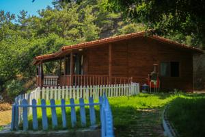 una casa de madera con una valla delante en Villa Zeytin, en Cıralı