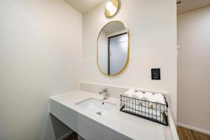 a white bathroom with a sink and a mirror at Hotel Yaja Changwon Myeongseo in Changwon