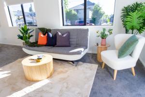 a living room with a couch and a chair at Gateway to Hagley park - 2 bed w/carpark in Christchurch