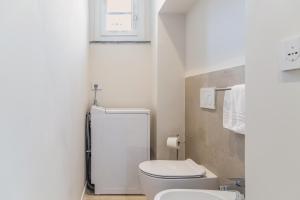 Un baño blanco con inodoro y lavabo. en VickyLù - City Center - by Host4U, en Pavia