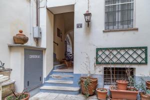 Un callejón con plantas en macetas al costado de un edificio. en VickyLù - City Center - by Host4U, en Pavia