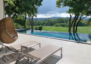 a patio with a chair and a swimming pool at Khaoyai Valley1 บ้านพักเขาใหญ่วัลเล่ย์1 in Mu Si
