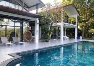 a swimming pool in front of a house at Khaoyai Valley1 บ้านพักเขาใหญ่วัลเล่ย์1 in Mu Si