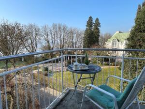 eine Terrasse mit einem Tisch und Stühlen auf dem Balkon in der Unterkunft Iris am See garni in Radolfzell am Bodensee