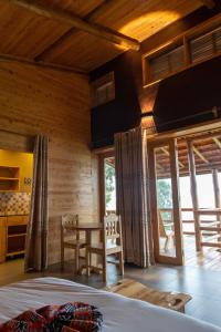um quarto com uma cama, uma mesa e cadeiras em Umutuzo lodge Kivu lake 