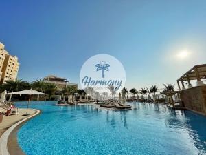 a large swimming pool with a sign that reads honeymoon at Harmony Vacation Homes - BALQIS Residence in Dubai