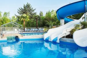 a water slide in a pool at a resort at Chalet à louer - 52m2 - Landes in Saint-Geours-de-Maremne +15 photos