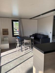 een keuken en een woonkamer met een tafel en stoelen bij Chalet à louer - 52m2 - Landes in Saint-Geours-de-Maremne