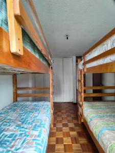 two bunk beds in a room with wooden floors at Mi Casa in Quito