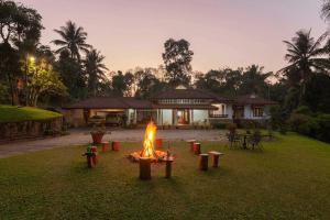 een brand in een tuin voor een huis bij Crystal Homestay by StayVista - 4BR in Madikeri