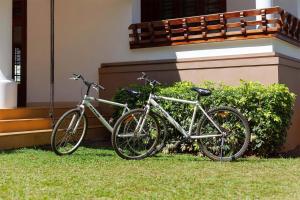 duas bicicletas estacionadas na relva ao lado de um edifício em StayVista at Crystal Homestay with Breakfast & Bicycle em Madikeri