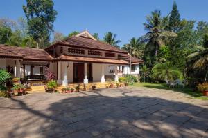 una casa con un patio frente a ella en StayVista at Crystal Homestay with Breakfast & Bicycle en Madikeri