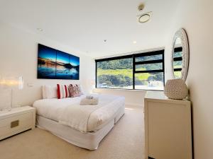 a bedroom with a white bed and a large window at Mt Maunganui Main Beach Luxury with Seaviews in Tauranga