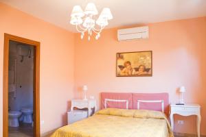 a bedroom with a bed and a painting on the wall at La Papaya in Marina di Pisa
