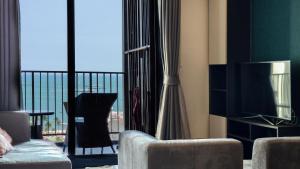 パタヤ・セントラルにあるパタヤ ビーチ シー ビュー ルーフトップ プール リゾートのソファとテレビのあるリビングルーム