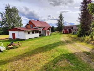 una casa con una mesa de picnic en un campo en Lappish Summerhouse by the River, en Kiemunkivaara