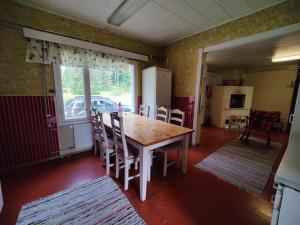 a kitchen with a table and chairs in a room at Lappish Summerhouse by the River in Kiemunkivaara
