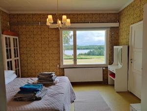 1 dormitorio con cama y ventana con vistas en Lappish Summerhouse by the River, en Kiemunkivaara