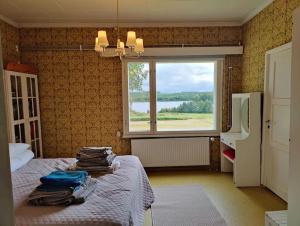 Un dormitorio con una cama y una ventana con vistas. en Lappish Summerhouse by the River, en Kiemunkivaara