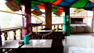 um restaurante com mesas e cadeiras numa sala com janelas em Baba Lao Hotel em Malindi