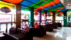 Zwei Personen sitzen in einem Restaurant mit farbenfrohen Decken. in der Unterkunft Baba Lao Hotel in Malindi