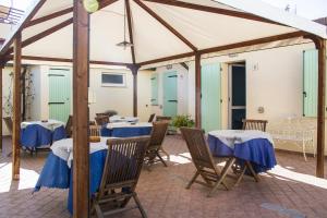 a group of tables and chairs under a tent at La Papaya in Marina di Pisa