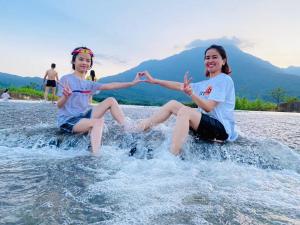 twee meisjes zitten op een rots in het water bij LaLi Home in Hanoi