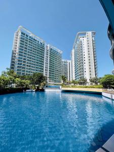 a large swimming pool in front of two tall buildings at The Bahama Hammock - Azure PH in Manila