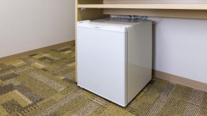 a small white refrigerator sitting under a counter at Toyoko Inn Hiroshima-eki Minami-guchi Migi in Hiroshima