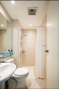 uma casa de banho com um WC, um lavatório e um chuveiro em The Bahama Hammock - Azure PH em Manilla