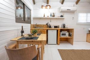 a kitchen with a wooden table and a refrigerator at שופרא ריזורט - וילה ובקתות - נופש וספורט Shoofra Resort Vacation Nature and Sport in Manot