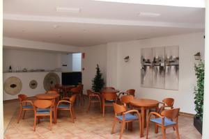 una habitación llena de mesas y sillas de madera en HOTEL HACIENDA SANTA BARBARA en Castilleja de la Cuesta