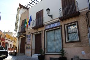 un edificio con un cartel en el costado en HOTEL HACIENDA SANTA BARBARA en Castilleja de la Cuesta