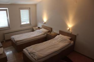 a room with two beds and two windows at Rooms Zebax in Sarajevo