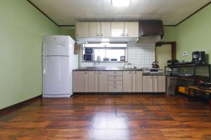 Il comprend une cuisine équipée d'un réfrigérateur blanc et du parquet. dans l'établissement Katori Resonal Sawara, à Katori