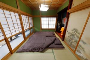 Ce lit se trouve dans un dortoir doté de murs verts et de fenêtres. dans l'établissement Katori Resonal Sawara, à Katori