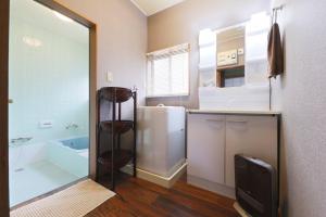 La salle de bains est pourvue d'une baignoire, d'un lavabo et d'une douche. dans l'établissement Katori Resonal Sawara, à Katori