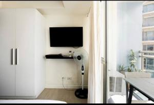uma sala de estar branca com uma televisão e uma mesa em The Bahama Hammock - Azure PH em Manilla