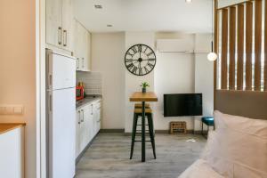 une cuisine avec une table et une horloge murale dans l'établissement Apartamento a un paso del mar, à Malaga