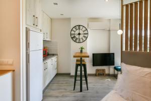 a kitchen with a table and a clock on the wall at Apartamento a un paso del mar in Málaga