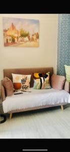 um sofá com almofadas na sala de estar em Amaia Steps Bicutan with Netflix and DisneyPlus - 1BR em Manila
