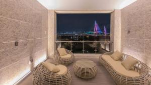 a balcony with wicker chairs and a view of a harbor at Yeongdo Grandbern Hotel in Busan