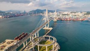 a bridge over the water with a city in the background at Yeongdo Grandbern Hotel in Busan