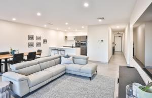 a living room with a couch and a table at Indulge Apartments - City View Penthouses in Mildura