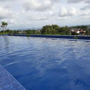 a large swimming pool with blue water at Mataram City 1816 by We Stay in Kejayan