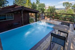 a small pool on a deck with a table and a chair at שופרא ריזורט - וילה ובקתות - נופש וספורט Shoofra Resort Vacation Nature and Sport in Manot